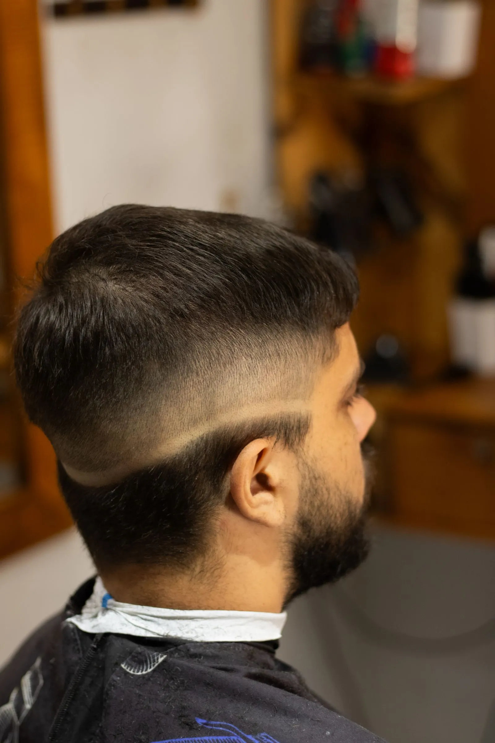 Corte degradado lateral con pesia peinada hacia arriba, perfil frontal